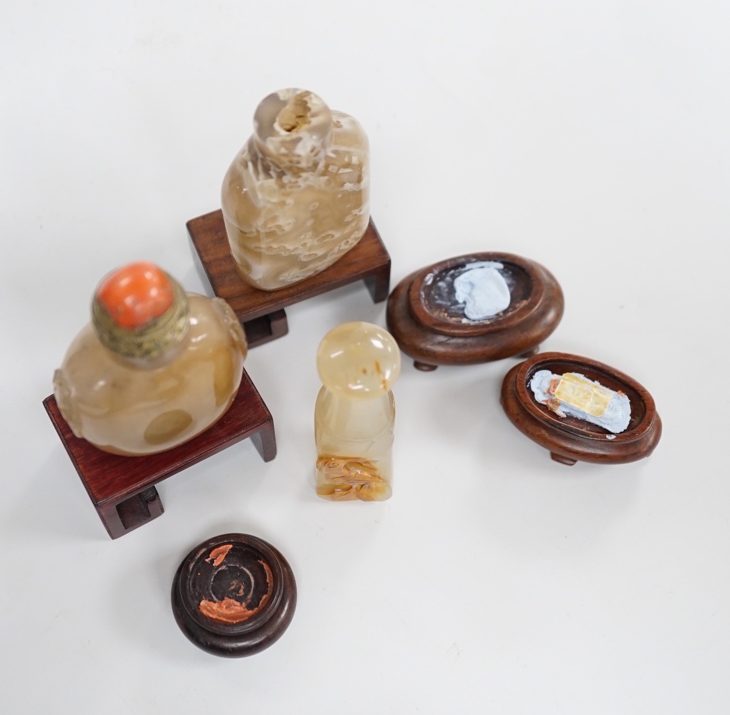 A Chinese chalcedony dendritic chalcedony (macaroni agate) snuff bottle, 5.7cm and a honey coloured agate mask and ring handled snuff bottle, 4.7cm, brass and coral stopper, both 1780-1880, together with a cameo agate pi